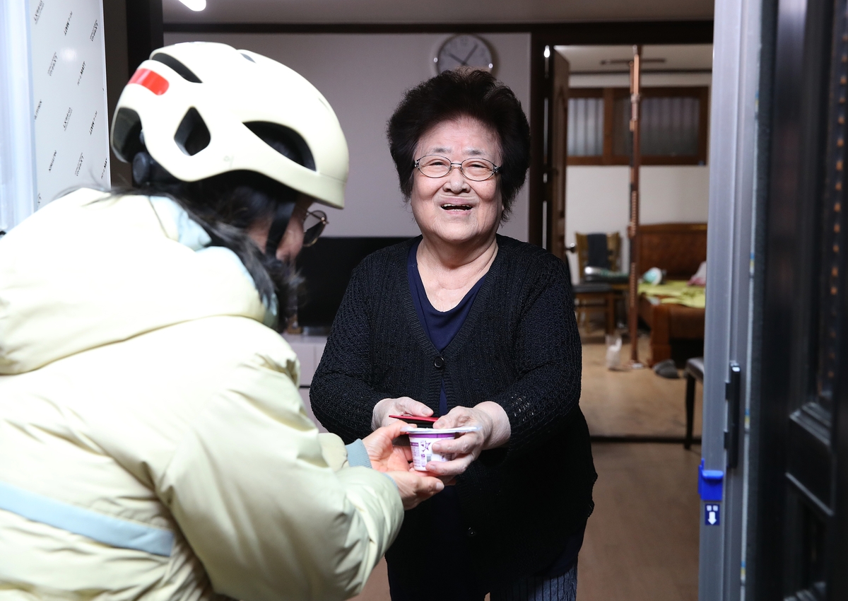 홀몸 노인에게 제품을 전달하고 있는 hy 프레시 매니저