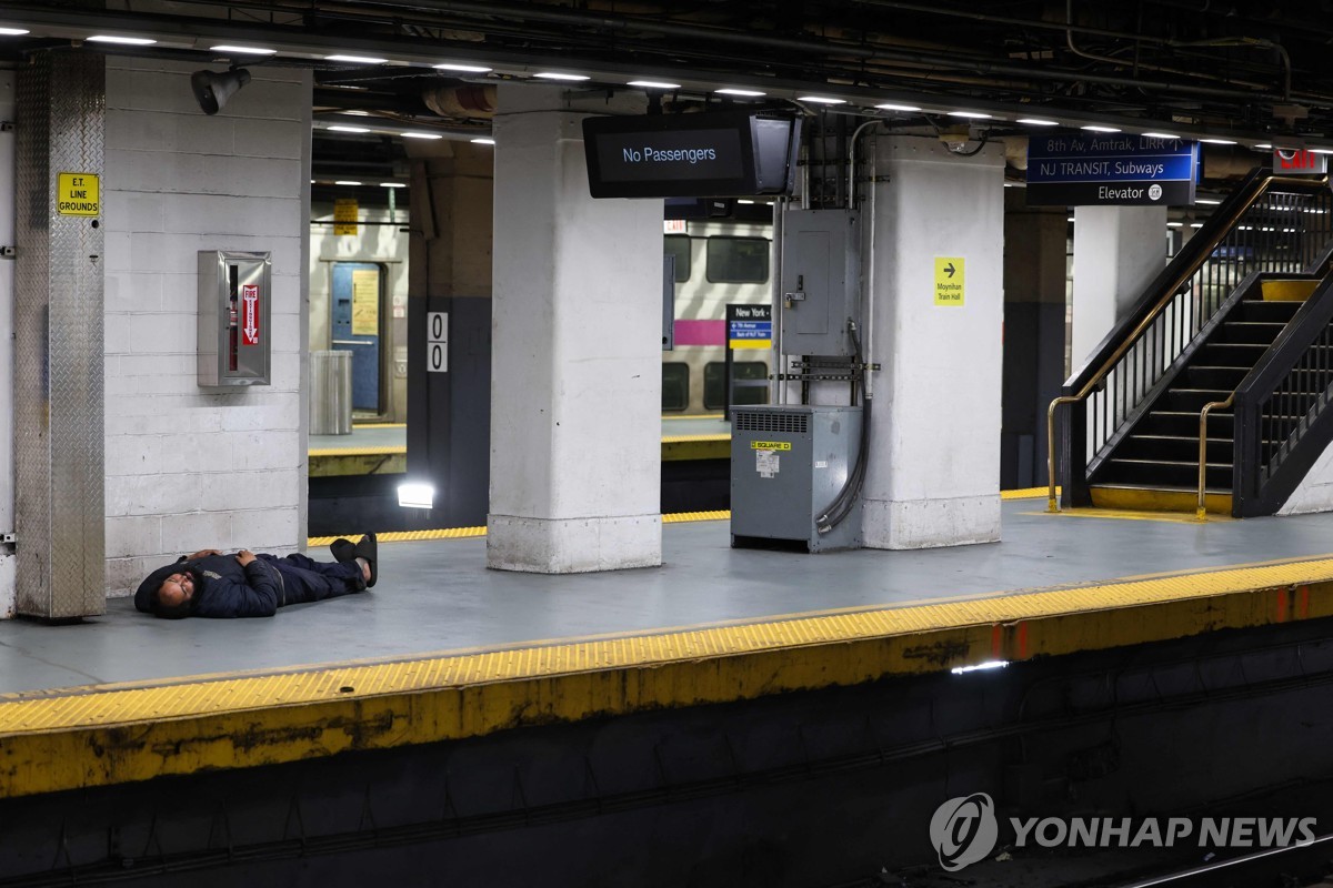 17(현지시간) 롱아일랜드 철도(LIRR) 파업으로 텅빈 선로에 한 노숙자가 잠들어 있다. 