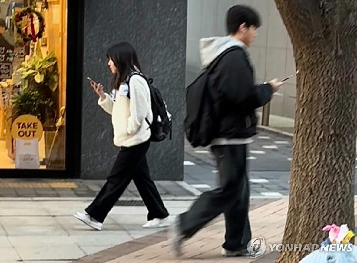 휴대폰을 보는 청소년