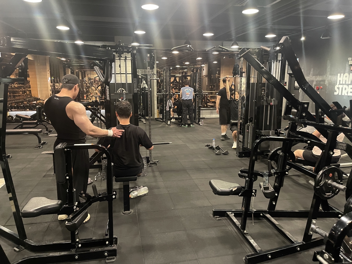 야간 시간 헬스장에서 운동하는 이용객들