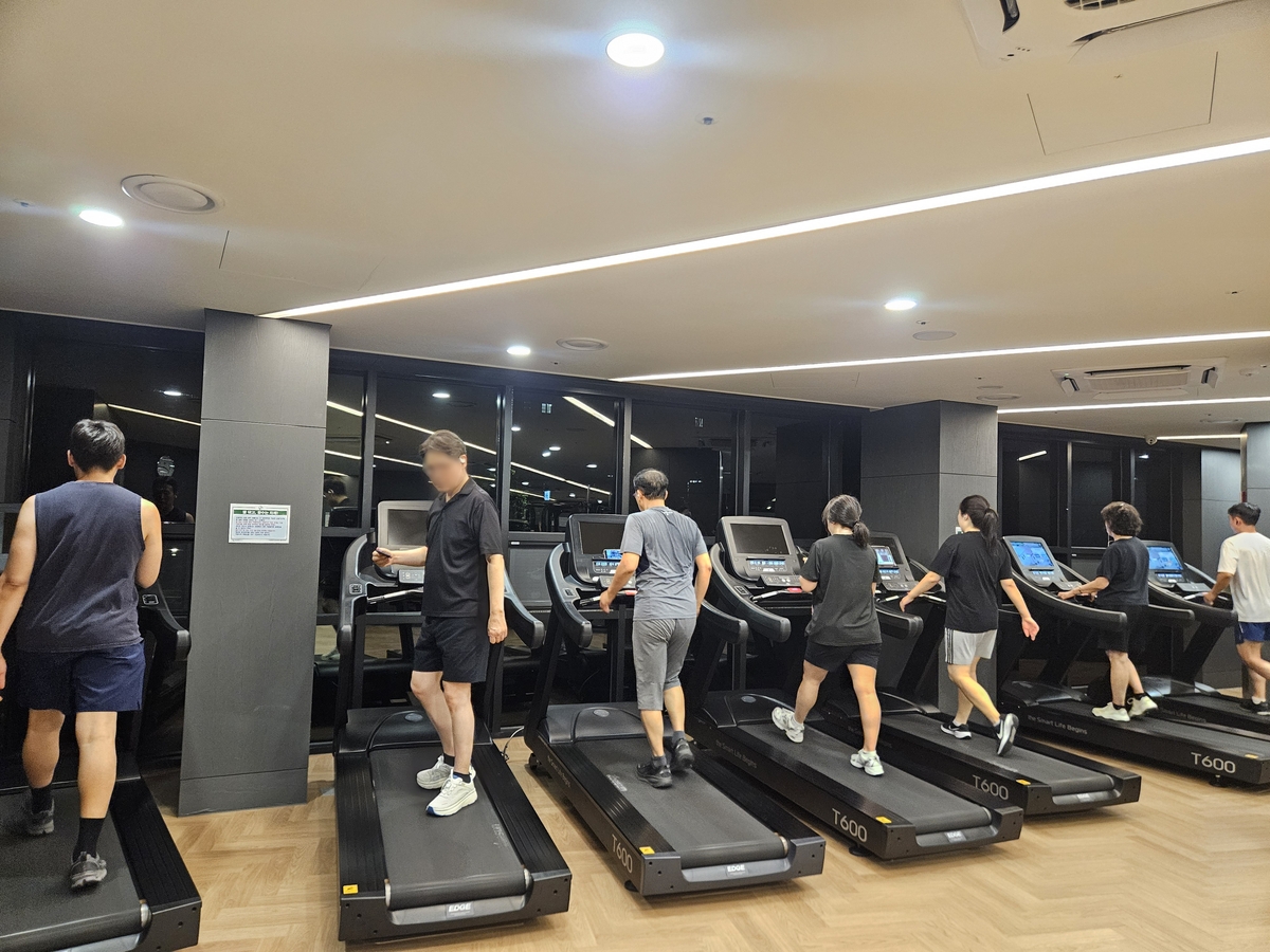 저녁 시간 아파트 헬스장에서 운동하는 주민들