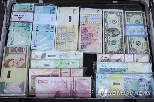 이란 수도 테헤란의 한 환전상에 리알화와 미화 지폐가 전시되어 있다. 