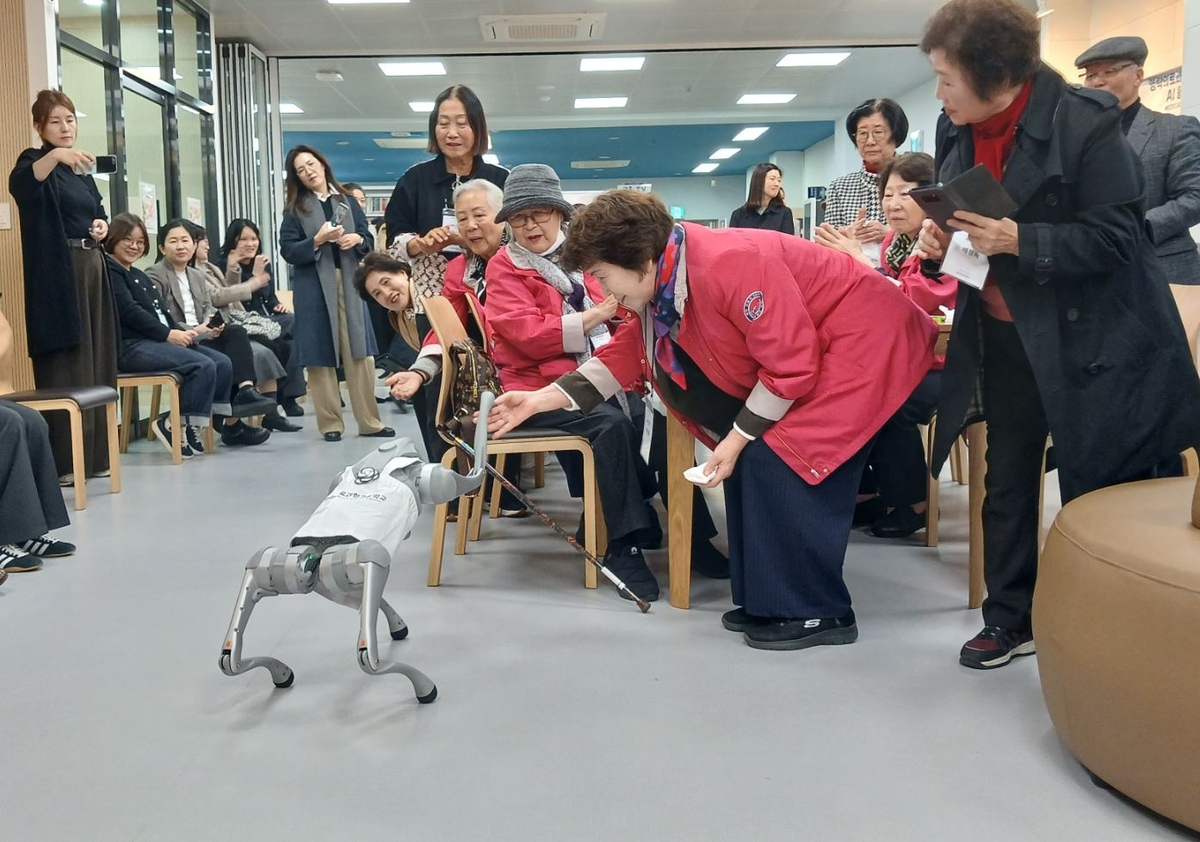 로봇 개와 악수하는 박소향 재독한인간호협회장