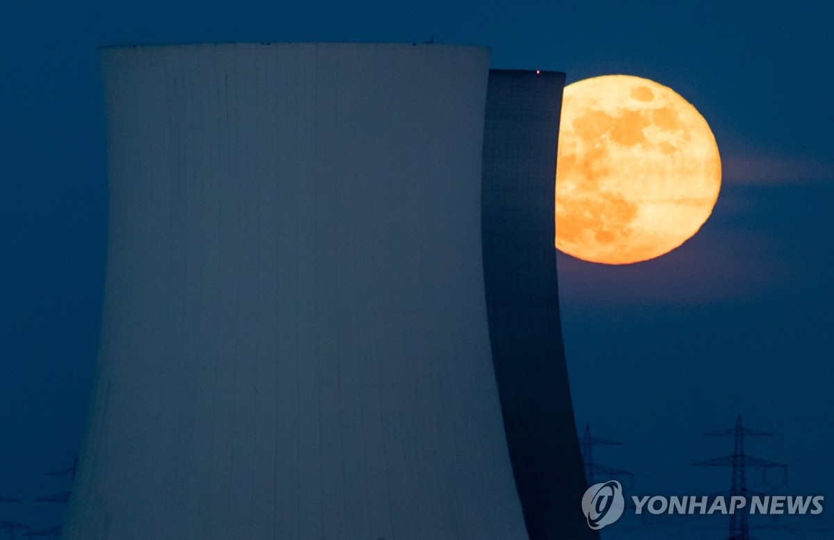 원전 냉각탑 뒤로 떠오르는 달