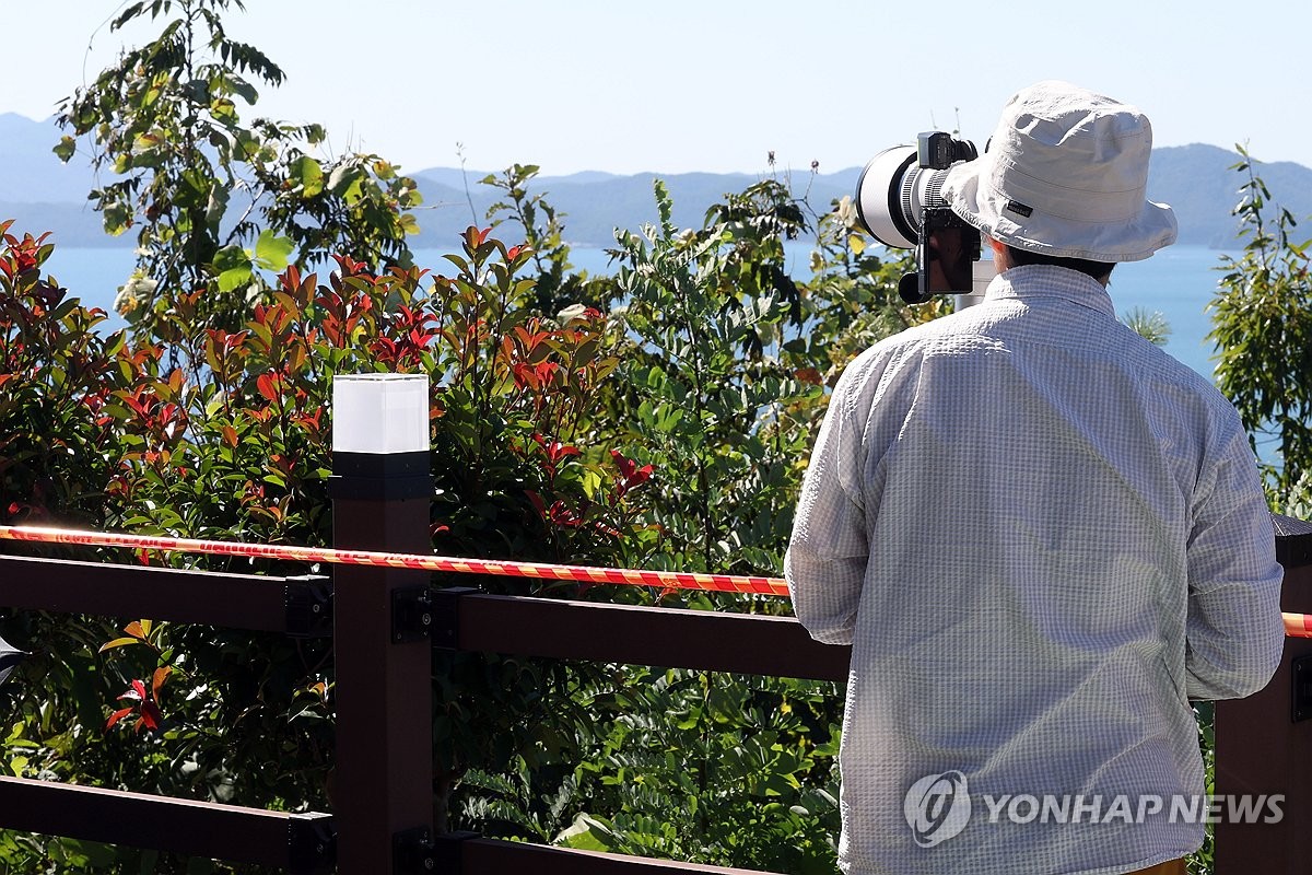 카메라로 발사대 주시하는 관람객
